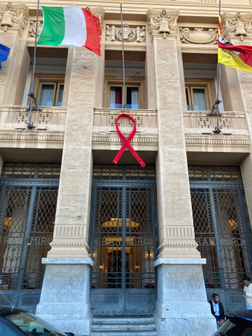 Un fiocco rosso orna la balconata di palazzo Zanca, illuminato di rosso per la giornata mondiale contro l’Aids